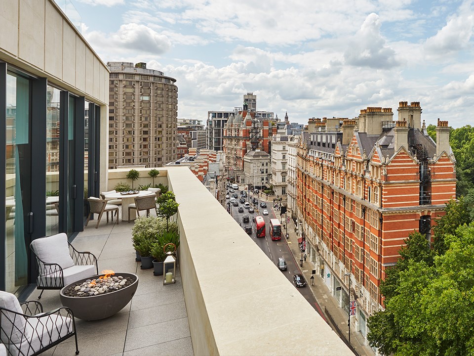 Terrace of the Hyde Park Penthouse at The Berkeley with armchairs and a firepit, and a view on Belgravia