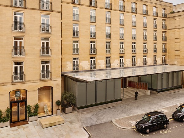 Exterior view of The Berkeley hotel in London, showcasing its elegant stone façade, modern glass canopy entrance, and black cabs parked at the kerbside.