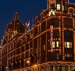 Harrods’ exterior at night, outlined in warm festive lights against a dark sky.