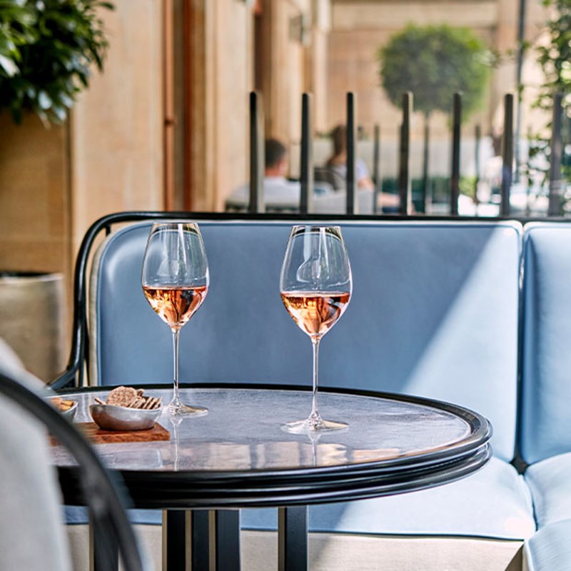 The Berkeley Bar & Terrace, a table with two glasses of rose and bar snacks.