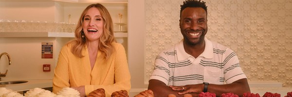 Grace Dent on the left and Jimi Famurewa on the right, smiling stood behind a selection of pastries and cakes by Cedric Grolet