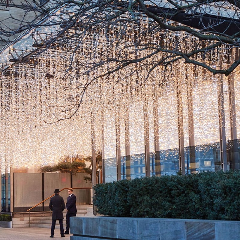 An intricately decorated gingerbread house with green and white icing, candy cane accents, and delicate piping details, evoking a whimsical holiday charm.
