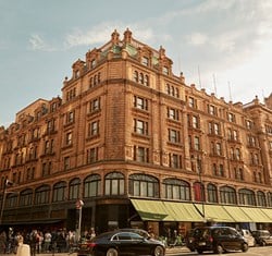 Another exterior view of Harrods with its ornate terracotta façade and green awnings.