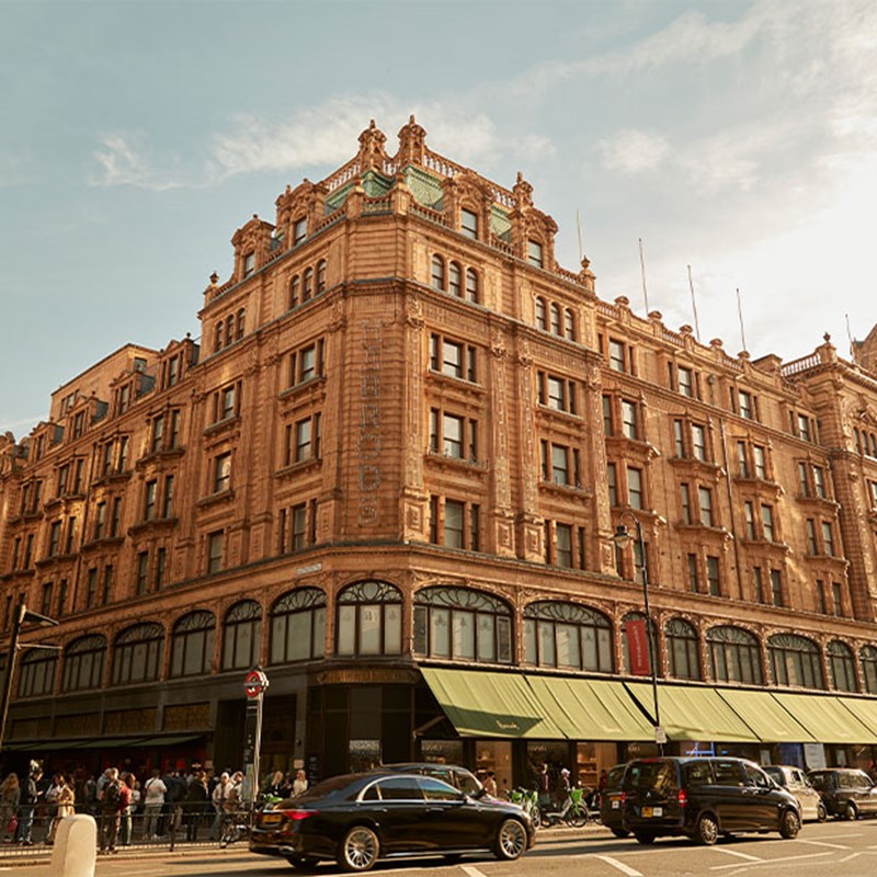 Another exterior view of Harrods with its ornate terracotta façade and green awnings.