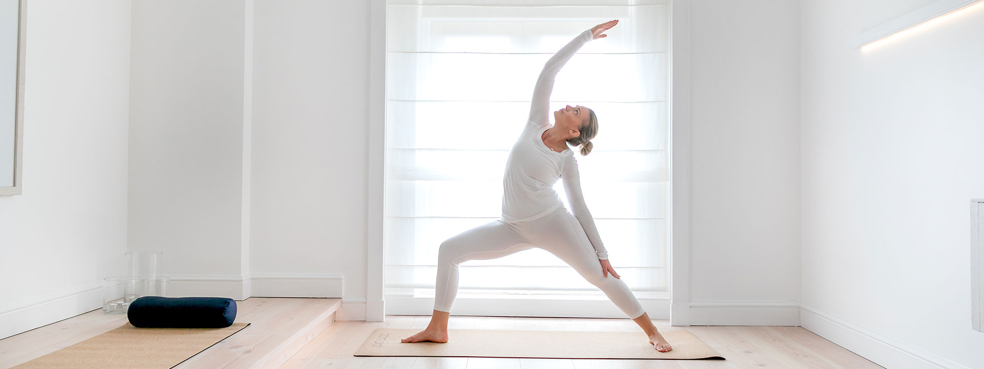 A woman doing yoga in the space of The Bamford Wellness Spa at The Berkeley, with lots of daylight.