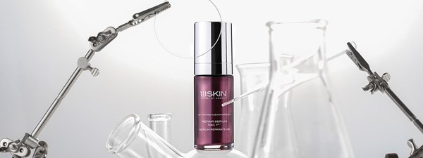 A product shot of a purple repair serum bottle in a laboratory setting.