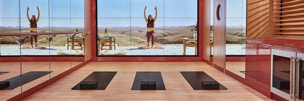 Surrenne yoga studio with mats, mirrors and large screen featuring an instructor based in the desert