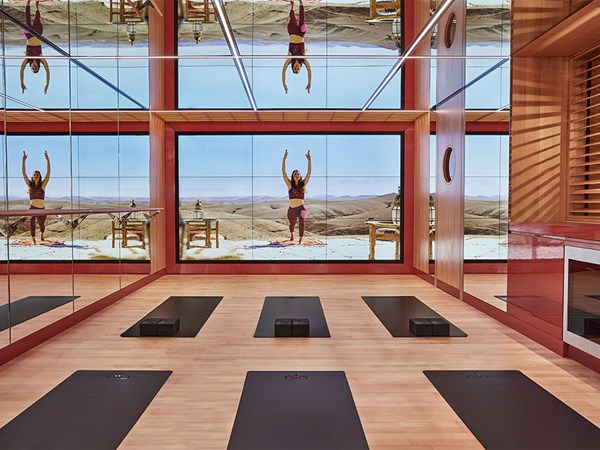 Surrenne yoga studio with mats, mirrors and large screen featuring an instructor based in the desert