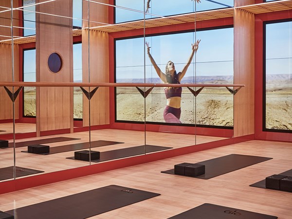 Surrenne yoga studio with mats, mirrors and large screen featuring an instructor based in the desert