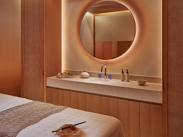 Surrenne treatment room featuring bed, basin, mirror and Surrenne products