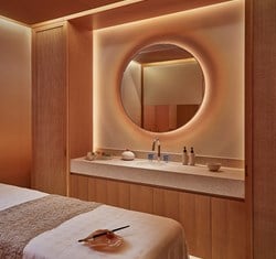 Surrenne treatment room featuring bed, basin, mirror and Surrenne products