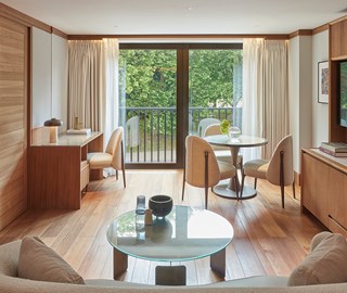 Dining and living area in room with wood decor overlooking a leafy scene