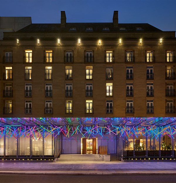 The Berkeley’s façade at dusk with colourful illuminated canopy over the entrance.