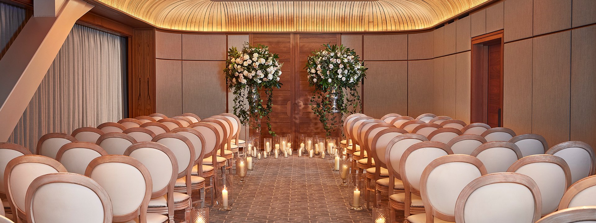Knightsbridge room set up as a private event with chairs set up with an alley and an arch.