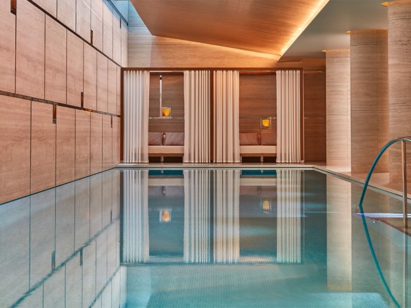Surrenne: swimming pool with  large pillars to the right and cabanas at the other end.