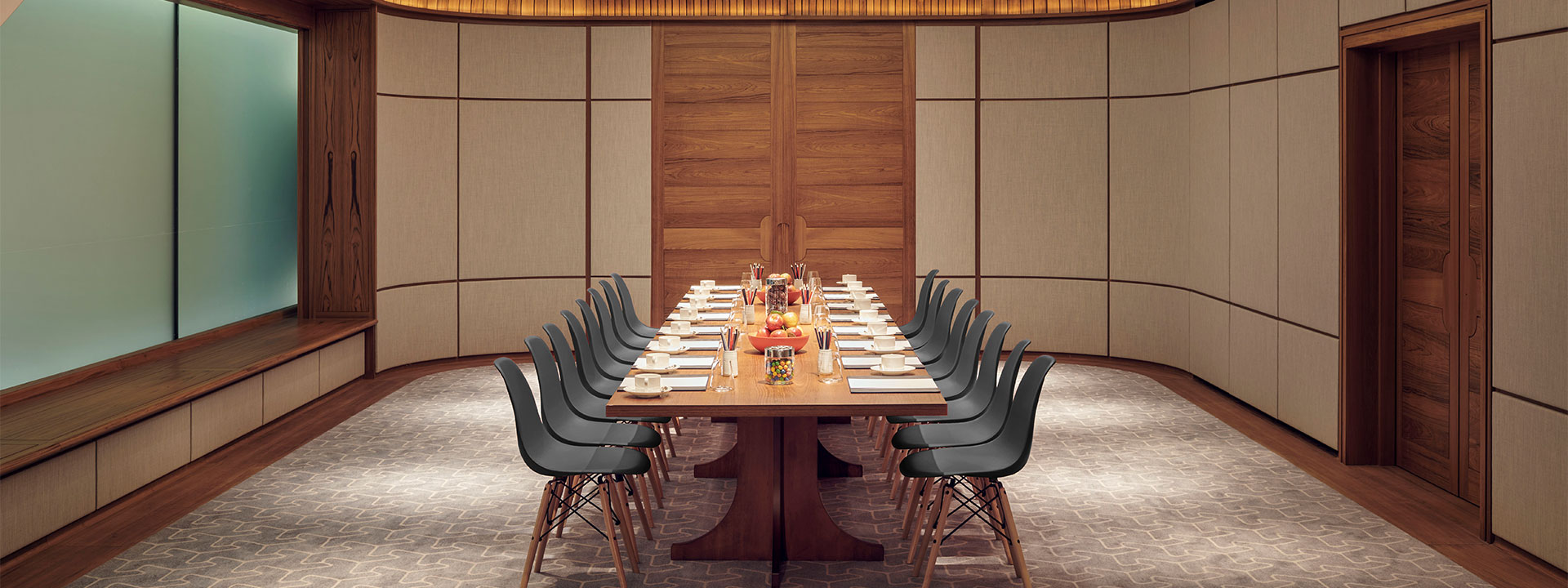 Massive wooden table in the centre of the Wilton Room, with comfortable chairs in a spacious and warm environment.