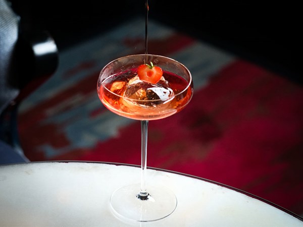 red cocktail in coup with strawberry