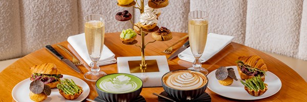 Goutea, tiered plates with sweet patisserie, savoury selection on  plates and 2 glasses of champagne, a latte and a matcha latte