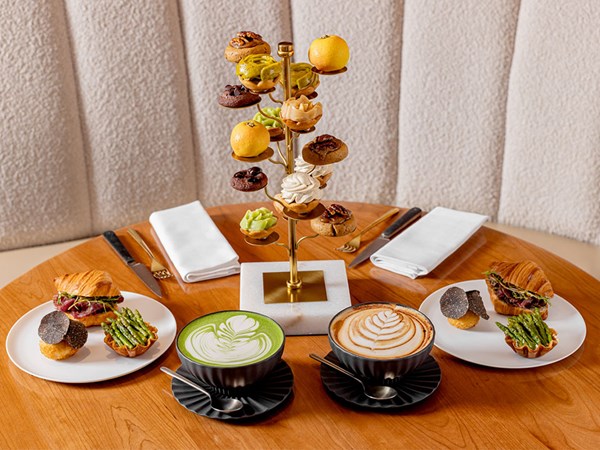 Goutea, tiered plates with sweet patisserie, savoury selection on plates, a latte and a matcha latte