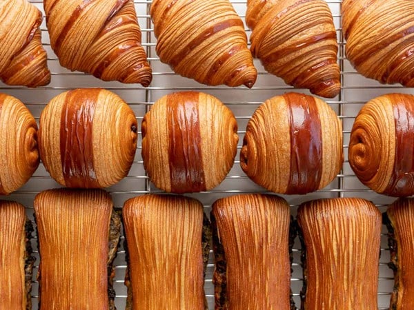 Rows of freshly bakes pastries like croissants and pain suisse