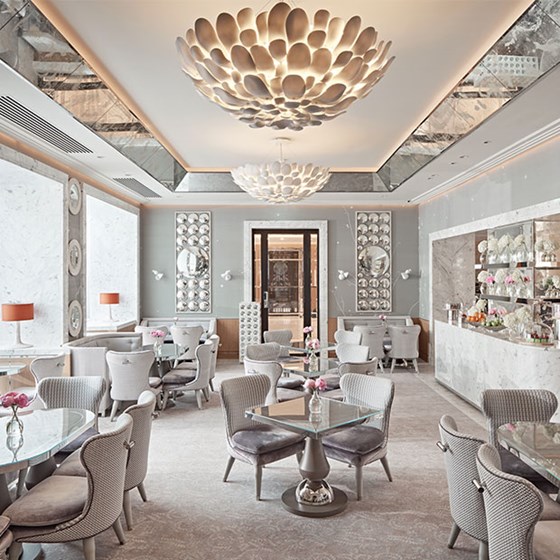 Collins Room restaurant light grey interior, with velvet grey seats, glass tables and silver wall decorations at The Berkeley