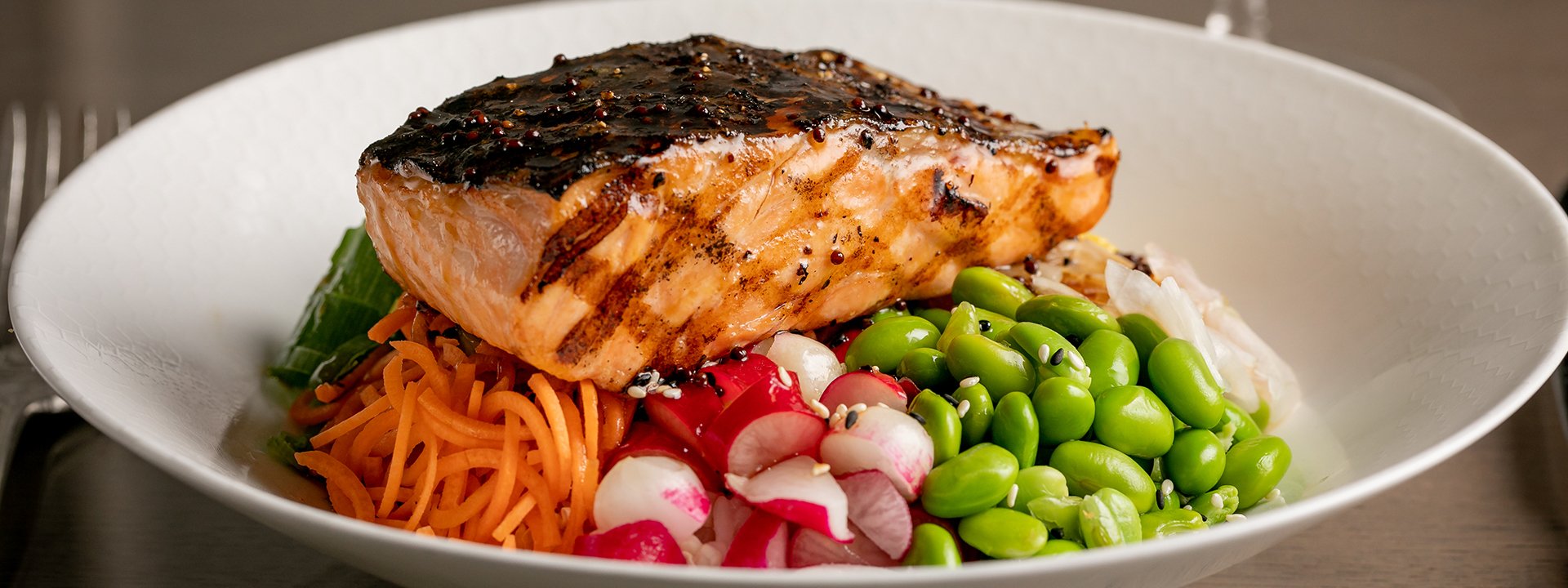 Grilled salmon on vegetables on a white plate, as one of the dishes at The Berkeley hotel.