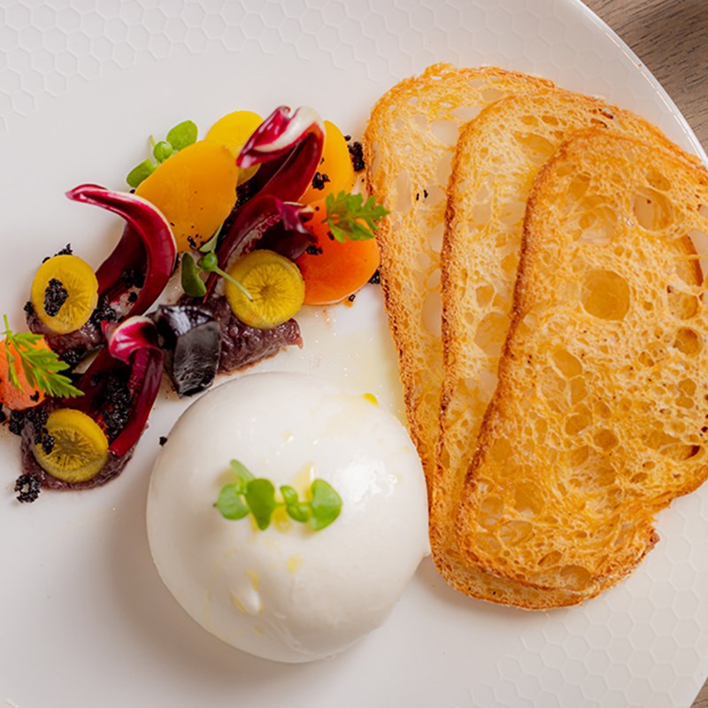 Mozarella with salad dressing and three slices of toasted bread at the Collins Room