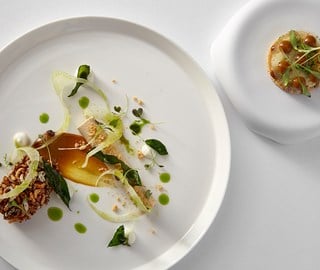 The Chefs Table at Marcus round white plate with plated food at The Berkeley