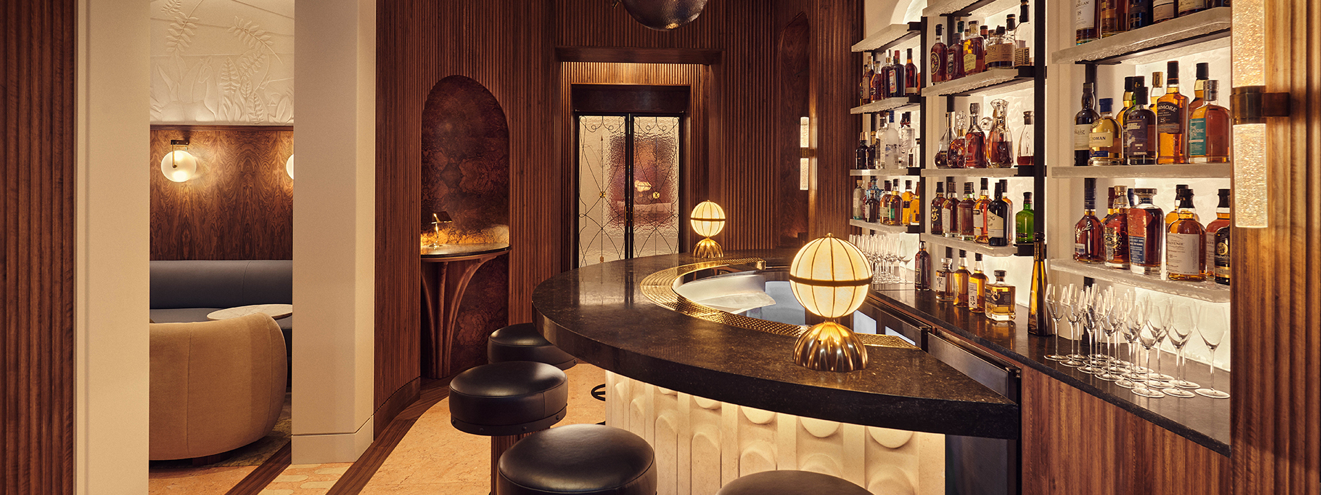 The Berkeley Bar & Terrace interior with  black marble semi circle bar, golden lighting and spirits displayed at The Berkeley