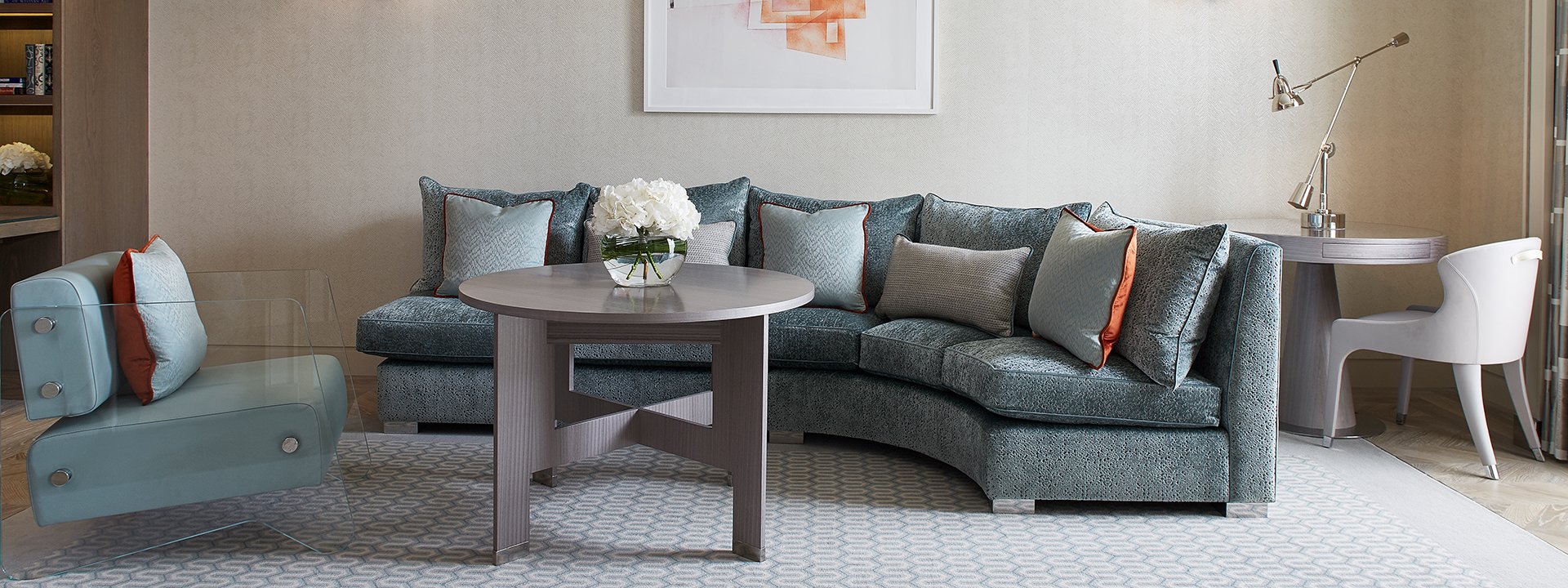 View of the blue living room in the Chelsea suite, with a comfortable sofa, armchair and luxurious elements.