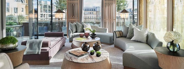 The living room in the Grand Pavilion Penthouse, with marble coffee tables and details, is a luxuriously designed interior.