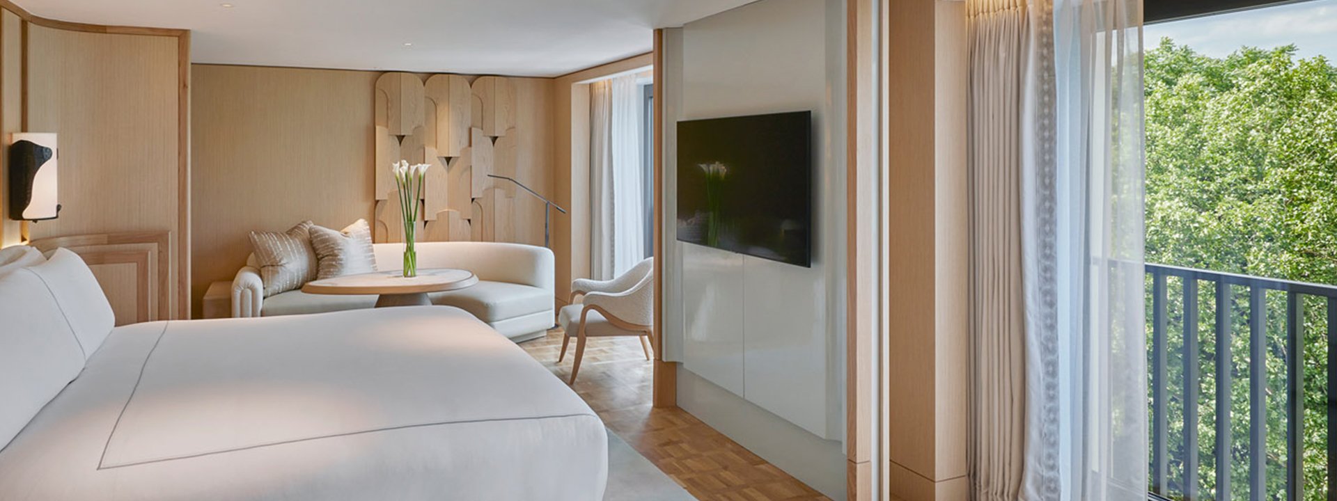 Knightsbridge Pavilion Penthouse - view of the bedroom with bed, sofa in the background, TV and windows on the right handside.