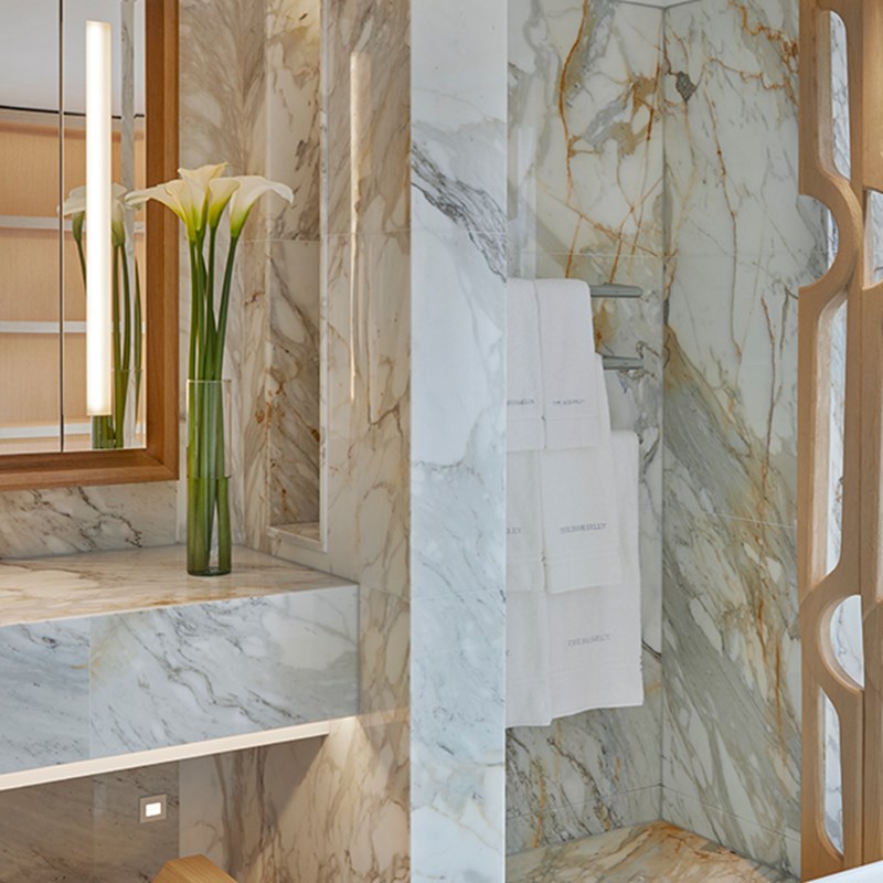 Knightsbridge Pavilion Penthouse - design details of the marble bathroom with rack for towels and flower in a vase.