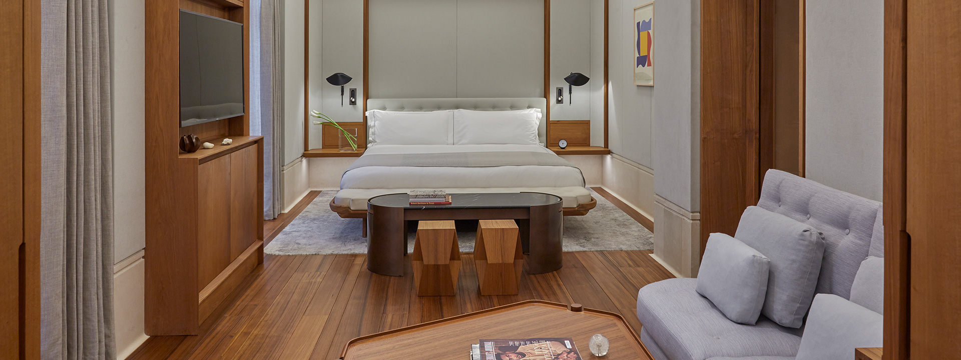 A comfortable King Bed in the bedroom of the Knightsbridge Suite, in an interior with wooden and natural design tones.