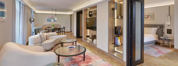 Suite living area with pink sofa, hanging lights and modern decor