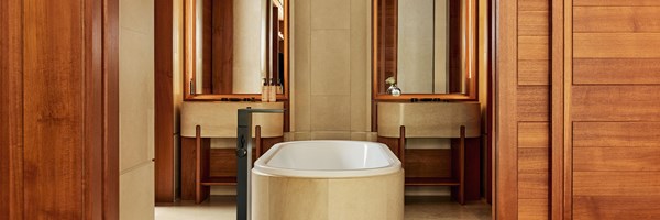 Bathroom in the Terrace Junior Suite at The Berkeley featuring a freestanding bathtub, twin vanities with mirrors, and warm wood and stone finishes.