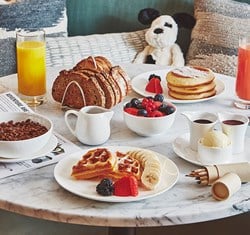 Children's breakfast in suite featuring coco pops, orange juice, toast, berries, pancakes,colouring pencils and jellycat toy dog
