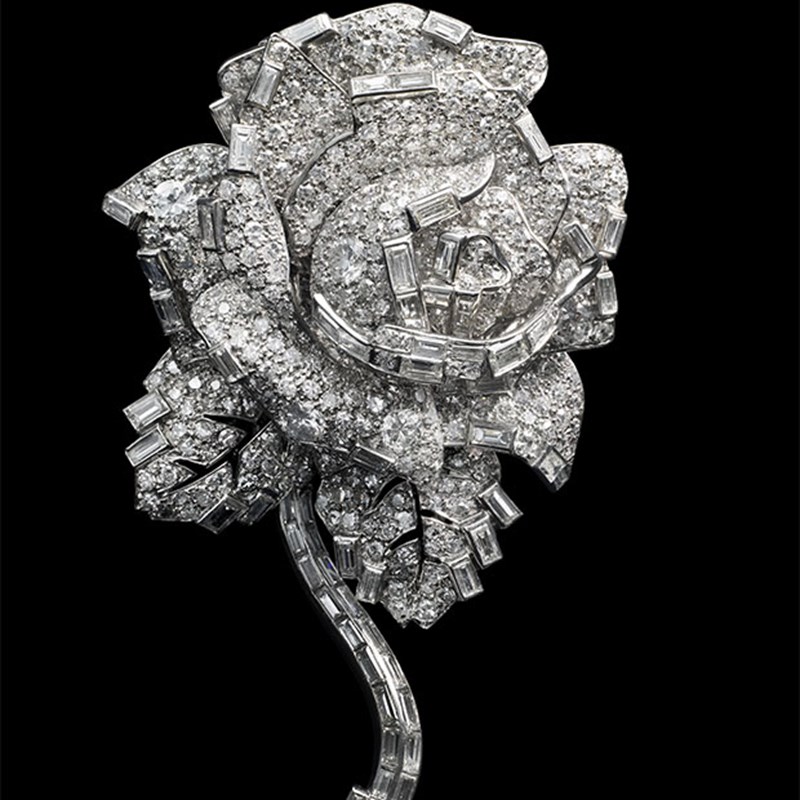 Geometric Cartier brooch in an Art Deco style, intricately arranged with brilliant-cut and baguette diamonds forming a symmetrical, architectural motif.