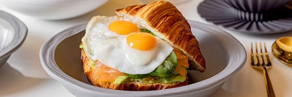 croissant stuffed with fried eggs, avocado and smoked salmon