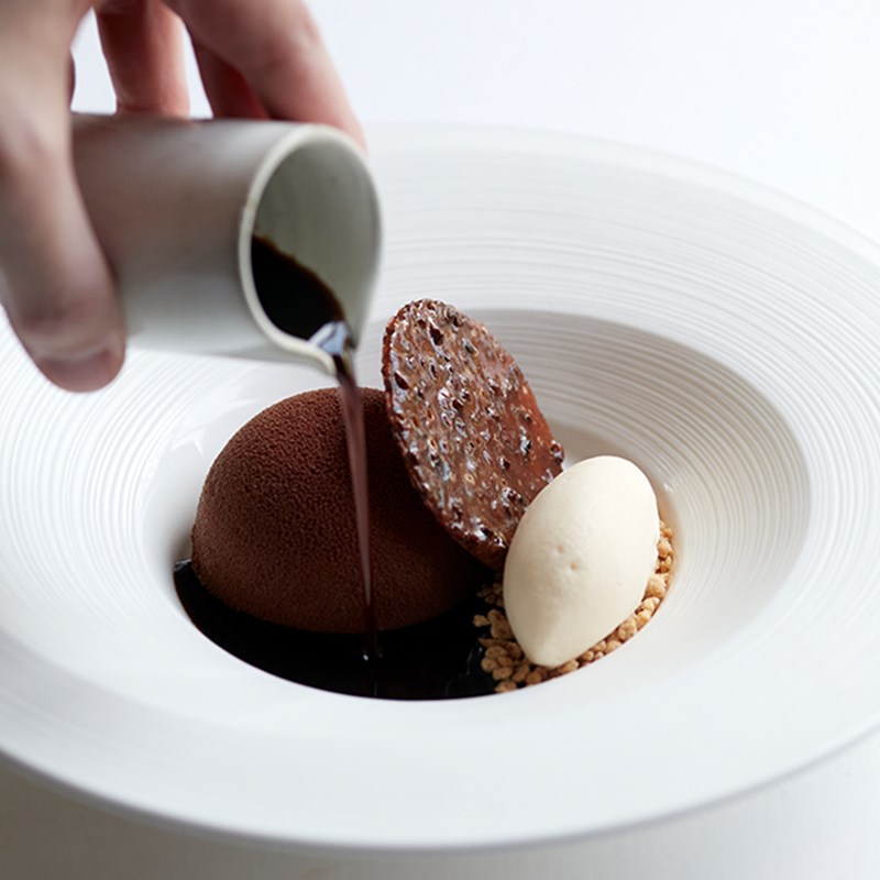 A chocolate dessert with chocolate sauce poured on top of it, at Marcus at The Berkeley.